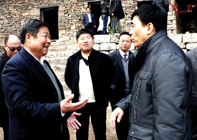 2012年3月，國務院扶貧辦副主任王國良（右），綜合司副司長張良（右三）到九間棚村調研農村脫貧工作